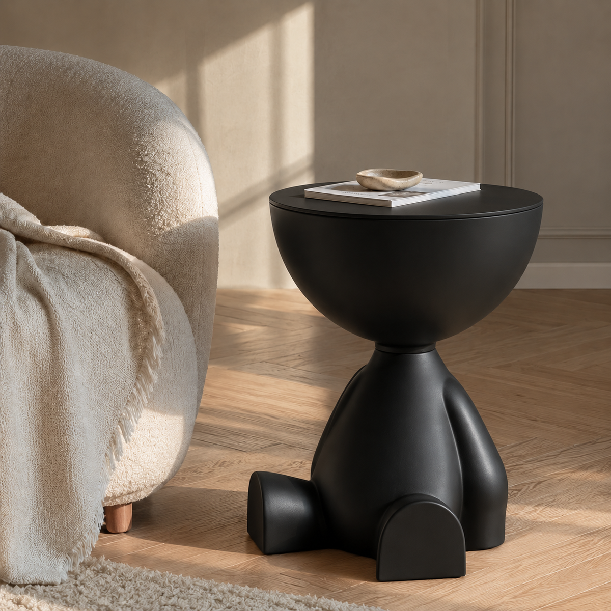 Table d'appoint ronde noir mat au design sculptural dans un salon lumineux